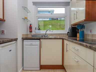 A kitchen with a sink dishwasher countertop and window at Florences Nest in Dartmouth