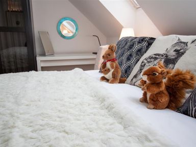 A bedroom with a bed featuring animal stuffed toys and pillows at The Arthouse in Ambleside