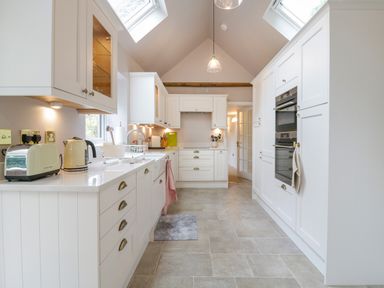 A kitchen with white cabinets and drawers with a toaster and kettle on the counter at West View in Feltwell