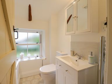 A bathroom with a toilet sink and mirror cabinet at West View in Feltwell