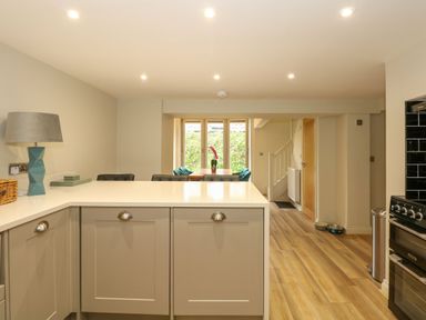 A kitchen with a countertop lamp and dining table with chairs near a window at Daisy's Place South Creake near Little Walsingham