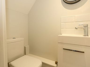 A small bathroom with a toilet and a sink with a faucet at Daisys Place in South Creake near Little Walsingham