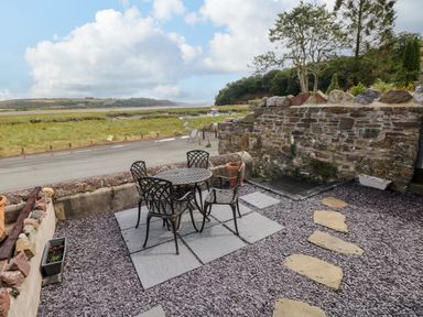 A patio area with a table and chairs at 2 Strand Cottages in Laugharne