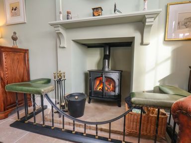 A living room with a fireplace and seating area at Roding Cottage in Egton
