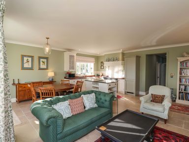 A living room with a sofa and dining area at Roding Cottage in Egton