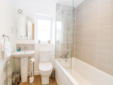 A bathroom with a sink mirror toilet bathtub and shower at Pine Cottage in Wrentham