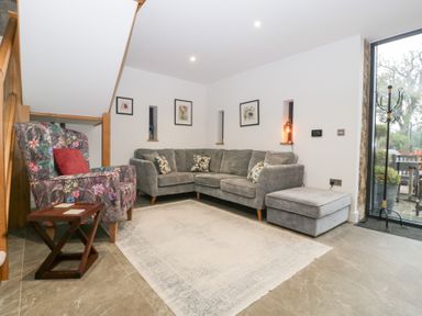 A living room with a sofa and chair at The Hay Barn in Huntley