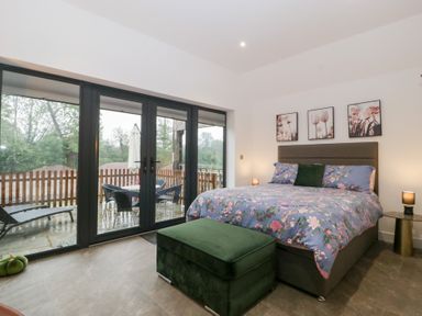 A bedroom with a bed and sliding doors at The Hay Barn in Huntley