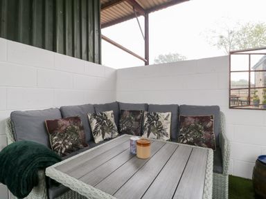 A seating area with a sofa and table at The Hay Barn in Huntley