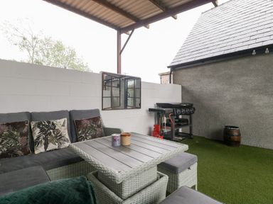 An outdoor patio with seating and a barbecue grill at The Hay Barn in Huntley