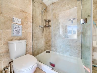 A bathroom with a toilet and a glass-enclosed shower at Bayview in Overcombe near Preston