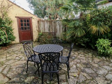 A garden with a table and chairs at Bridge Cottage in Budleigh Salterton