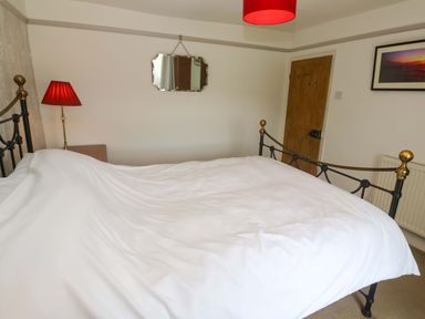 A bedroom with a bed and lamp at Greenways in Perranporth