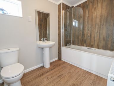 A bathroom with a toilet sink and bathtub with a shower at Hazelwood 2 Pinewood near Lyme Regis