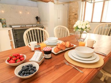 A dining room with a breakfast table set at 8 Gloucester Street in Winchcombe