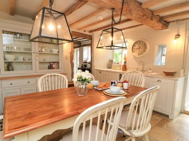 A dining room with a wooden table and chairs at 8 Gloucester Street Winchcombe
