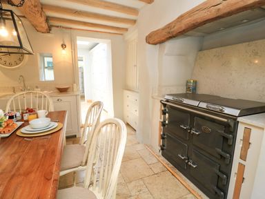 A kitchen with a dining table and an oven at 8 Gloucester Street Winchcombe
