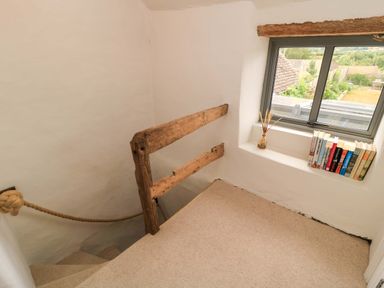 A staircase with a railing and window at 8 Gloucester Street Winchcombe