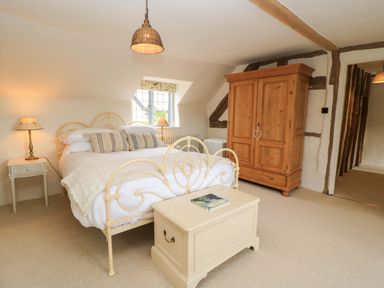 A bedroom with a bed and wardrobe at 8 Gloucester Street in Winchcombe