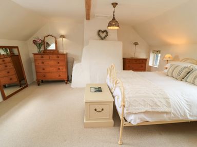 A bedroom with bed, nightstand, and chest of drawers at 8 Gloucester Street Winchcombe