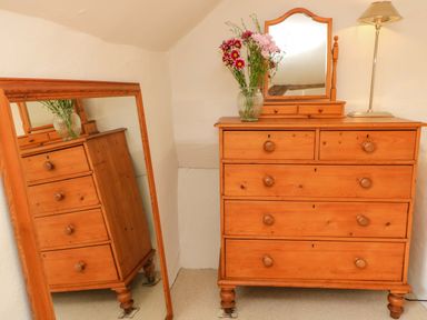 A dresser with a mirror and flowers at 8 Gloucester Street in Winchcombe