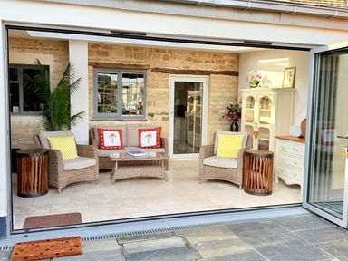 A conservatory with seating and a coffee table at The Garden Retreat in Winchcombe