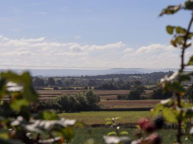 A rural landscape with fields trees and hills in the distance at The Alms House East in Forthampton near Tewkesbury