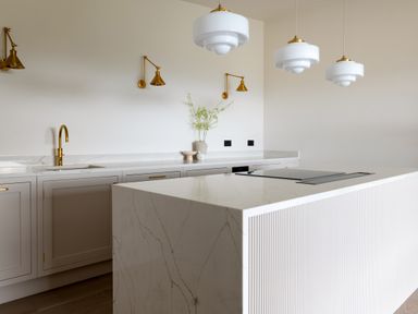 A kitchen with white marble island and brass fixtures at The Lookout in Longridge