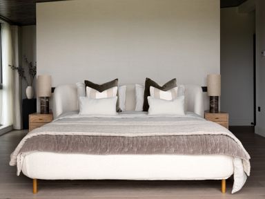 A bed with multiple pillows and blankets with bedside tables and lamps on either side at The Lookout in Longridge