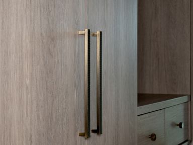 Close up of wooden cabinet doors with vertical metal handles