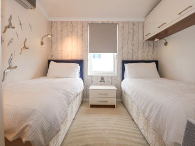 A bedroom with two single beds and a nightstand between them at The Warren M45 in Abersoch