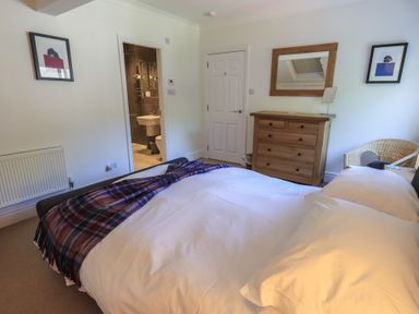 A bedroom with a bed and a dresser at Waterfall in Ambleside
