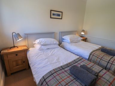 A bedroom with twin beds and bedside lamps at Waterfall in Ambleside