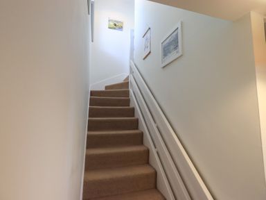 A staircase with carpet and wall frames at Waterfall in Ambleside