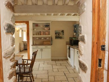 A kitchen with dining table and stone walls at Orchard Barn in Wexford