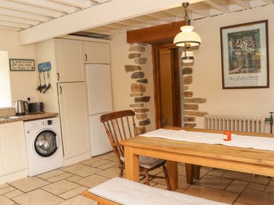 A kitchen with a table and chairs at Orchard Barn in Wexford