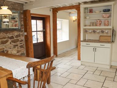 A kitchen with a table and shelf at Orchard Barn in Wexford