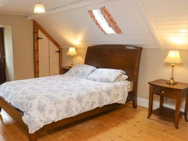 A bedroom with a bed and nightstand at Orchard Barn in Wexford