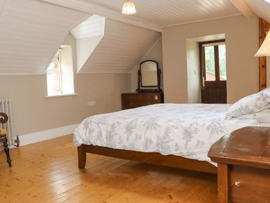 A bedroom with a bed and a chest of drawers at Orchard Barn in Wexford