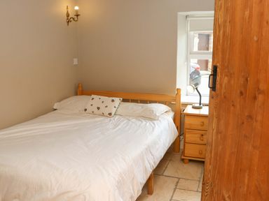 A bedroom with a double bed and bedside table at Orchard Barn in Wexford