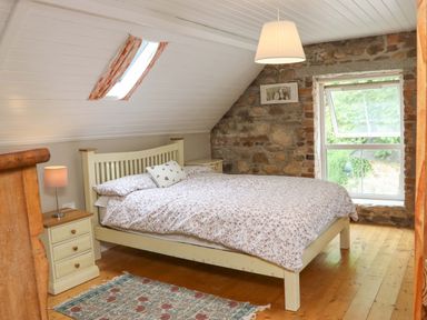 A bedroom with a bed and nightstand at Orchard Barn in Wexford