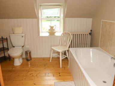 A bathroom with a bathtub and toilet at Orchard Barn in Wexford