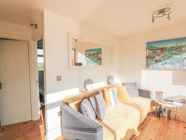 A living room with a gray and beige sofa with cushions a white oval table and a painting on the wall at 418 Norton Park in Dartmouth