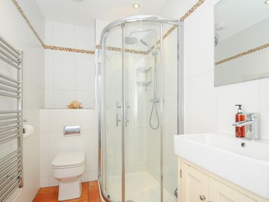 A bathroom with a corner shower cubicle toilet sink and a heated towel rail at Bryher in Trebetherick near Polzeath
