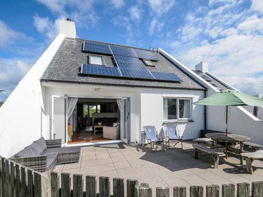A patio with outdoor seating and solar panels on roof at Bryher in Trebetherick near Polzeath