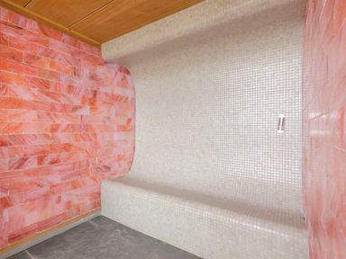 A curved white tiled bench against pink tiled walls in a room at Rowena in Mullion