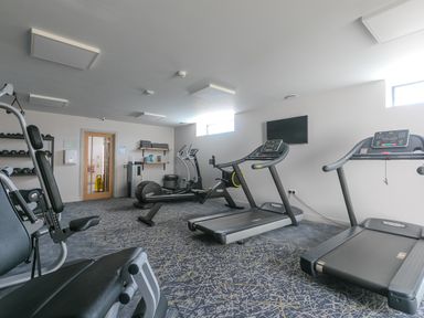 A gym room with treadmills and exercise machines at Rowena in Mullion