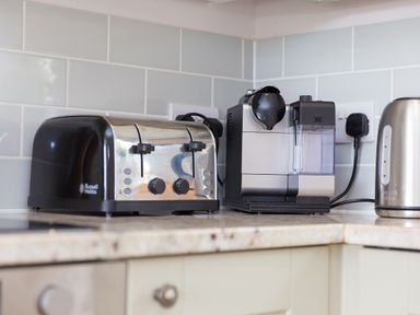 A kitchen countertop with a toaster coffee machine and kettle at Morwenna in Mullion