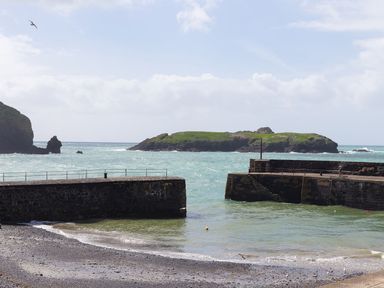 A view of the sea with an island and pier at Morwenna in Mullion
