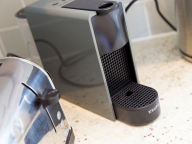 A black Krups coffee machine on a kitchen countertop